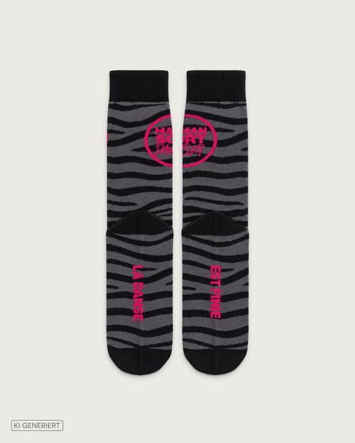 Schwarz-graue Socken mit Zebramuster, pinkem MAMANSORTDANSER Logo und den Schriftzügen „La Danse“ und „Est Finie“ auf den Sohlen