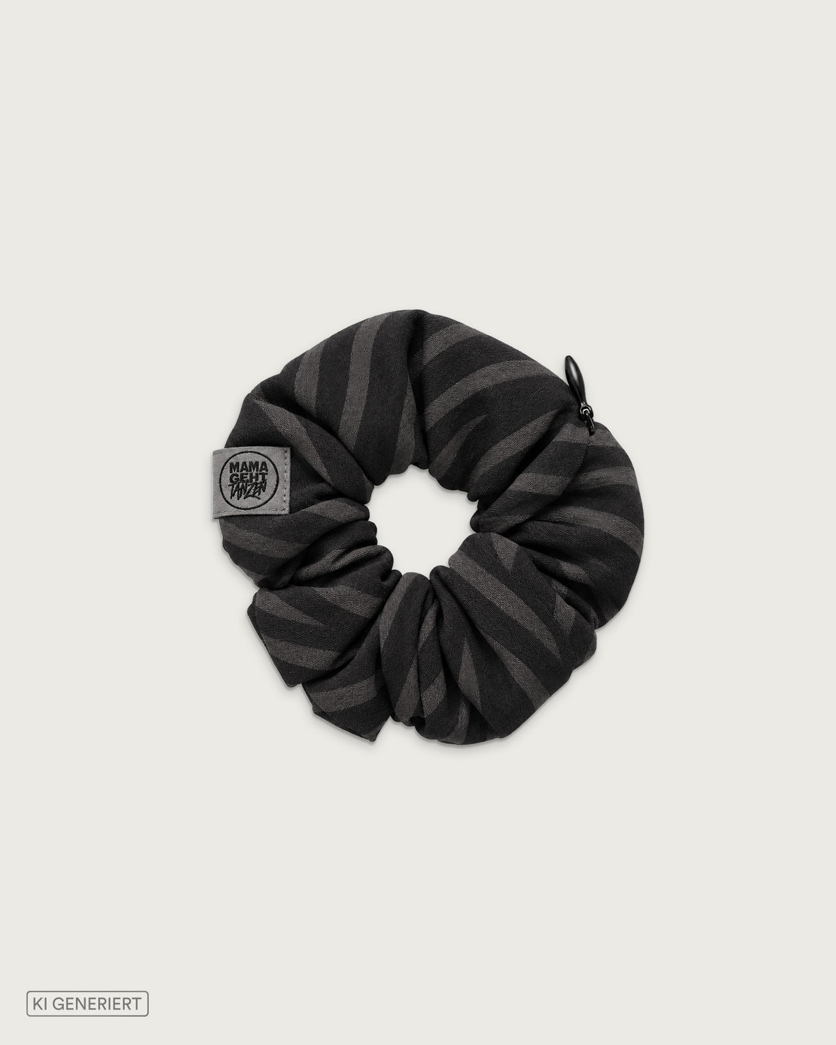 Schwarz-graues Scrunchie mit Zebramuster, integriertem Reißverschlussfach und MAMAGEHTTANZEN Logo-Label